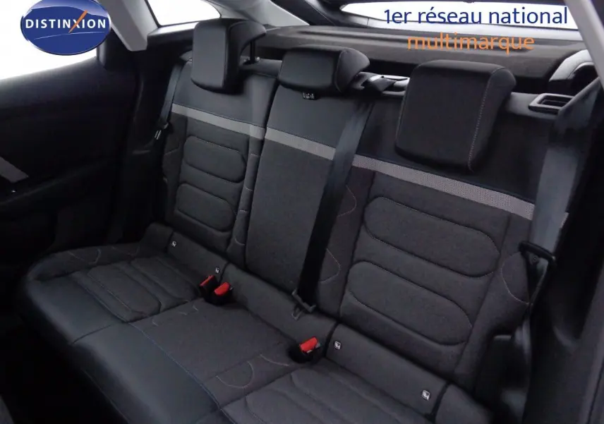 Vue intérieure arrière des sièges arrière gris foncé de la Citroën C4 2023 avec appuie-têtes et ceintures visibles.