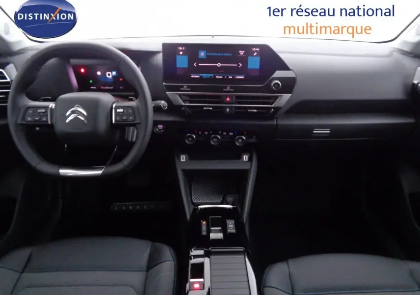 Intérieur de la Citroën C4 2023 en gris, vue frontale du tableau de bord avec écran tactile et volant multifonction.