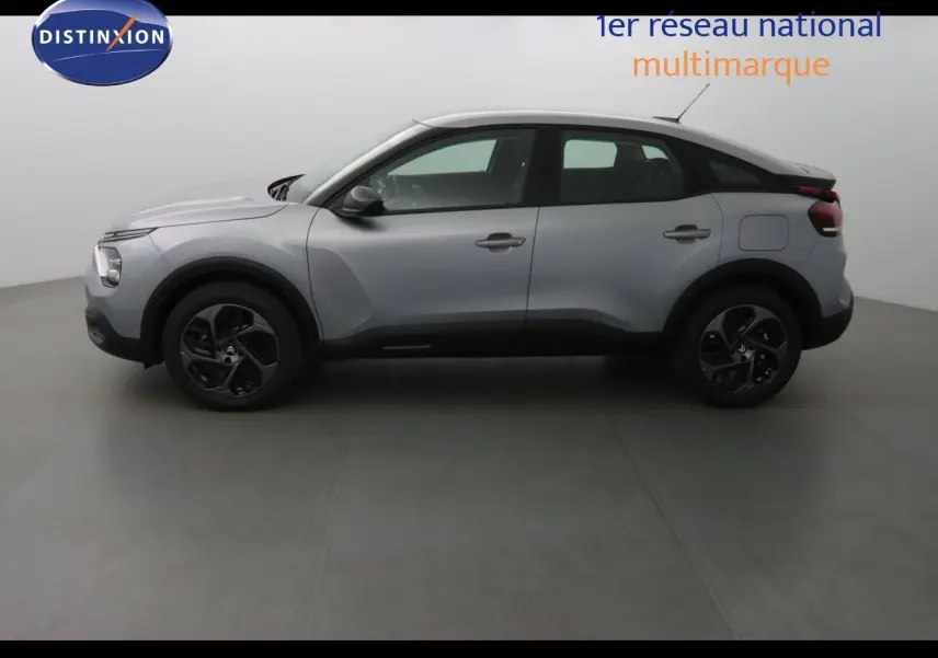 Profil côté gauche d'une Citroën C4 2023 gris Artense métal avec jantes noires et lignes sculptées.
