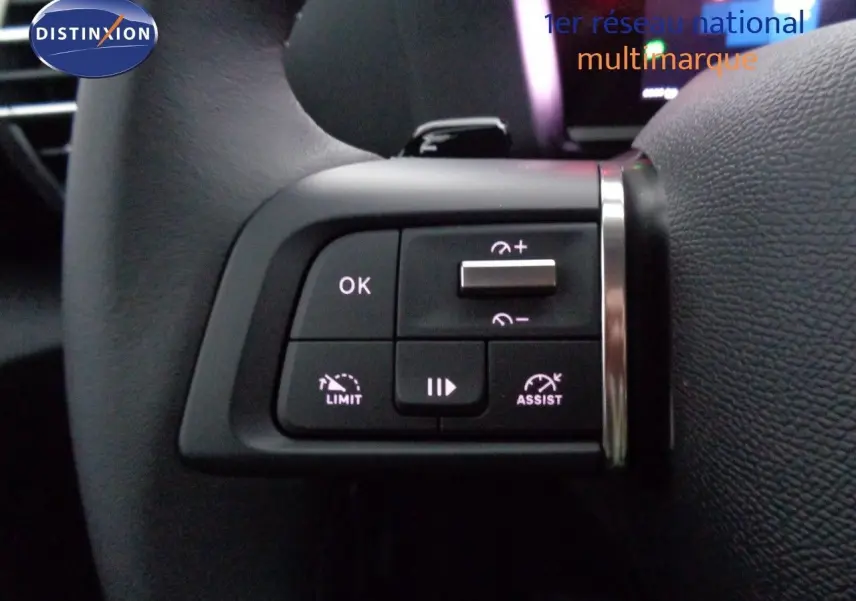 Gros plan sur les commandes au volant du Citroën C4 2023, avec boutons de limitation et assistance de vitesse.
