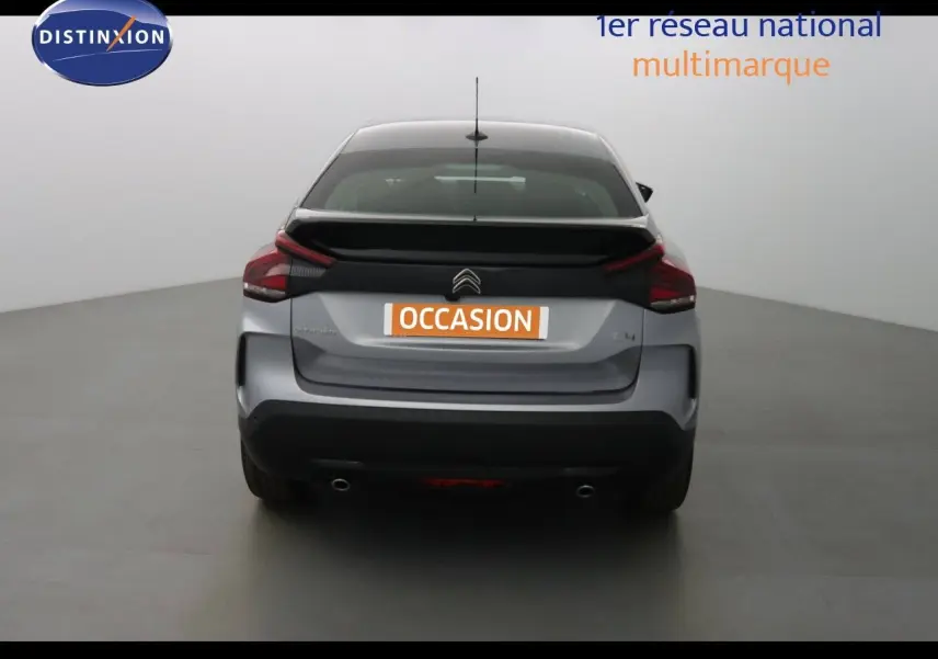 Vue arrière d'une Citroën C4 gris Artense métal 2023 avec feux arrière distinctifs et double sortie d'échappement.