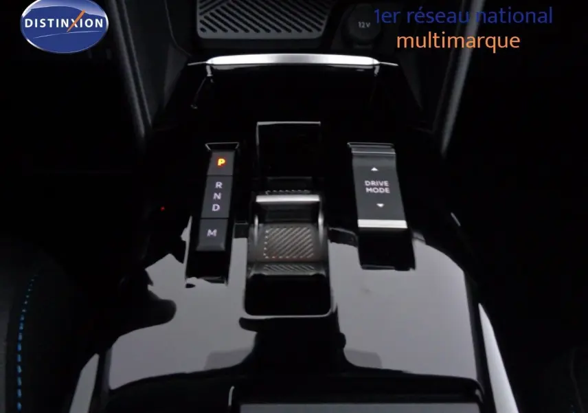 Gros plan sur la console centrale noire brillante de la Citroën C4 2023, avec sélecteur de boîte auto et bouton Drive Mode.