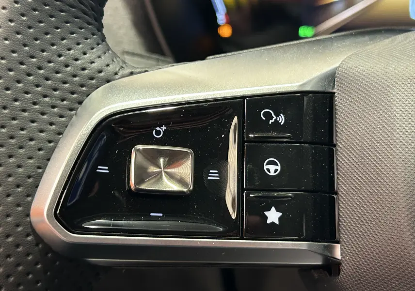 Gros plan sur les commandes noires et argentées au volant du MG ZS Cosmic Silver 2025, version hybride.