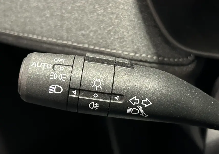Gros plan sur la commande de feux et clignotants noire avec pictogrammes blancs dans l’habitacle du MG ZS Cosmic Silver 2025.