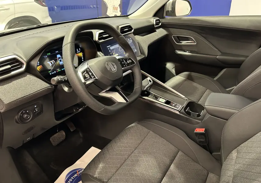 Vue intérieure côté conducteur du MG ZS Cosmic Silver 2025, volant multifonction et tableau de bord digital.