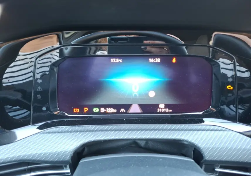 Vue rapprochée du tableau de bord numérique de la Volkswagen Golf blanche, affichant la vitesse et les informations de conduite.