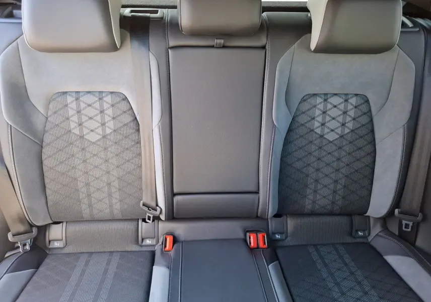 Vue rapprochée des sièges arrière noirs et gris de la Volkswagen Golf 1.5 E-TSI R-Line 2023 avec ceintures visibles.