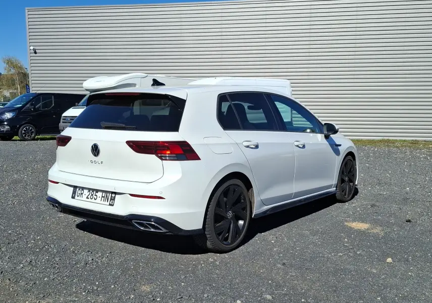 Volkswagen Golf 1.5 E-TSI R-Line blanche vue 3/4 arrière droit, jantes noires et vitres arrière surteintées.