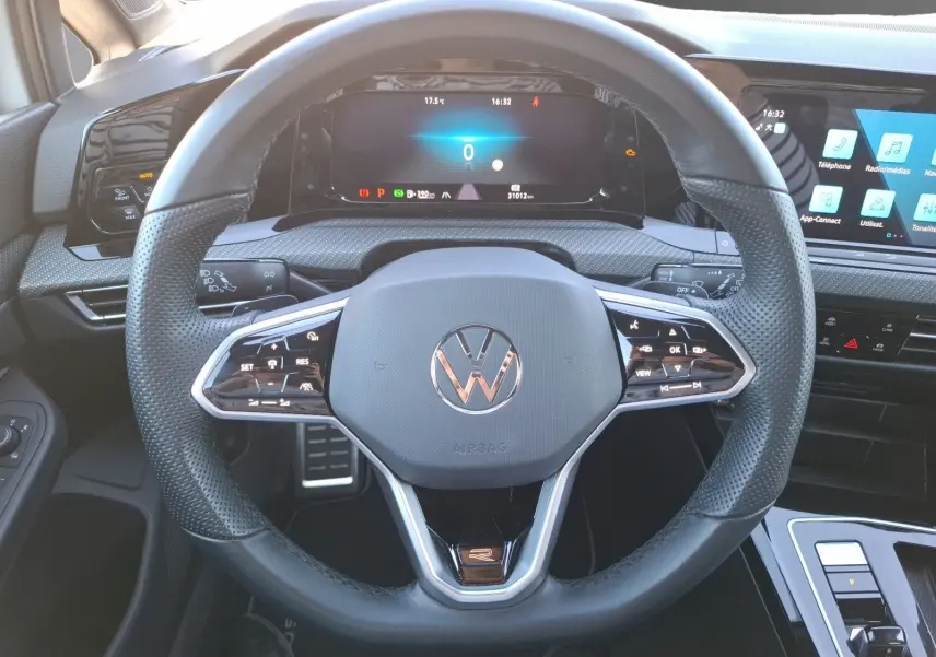 Vue rapprochée du volant multifonction noir de la Volkswagen Golf 1.5 E-TSI R-Line 2023 avec tableau de bord numérique.