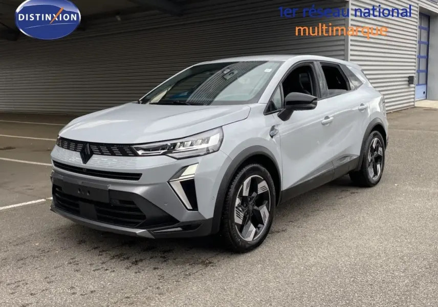 Renault Symbioz gris Rafale métal en 3/4 avant droit, SUV hybride avec calandre noire et jantes bicolores modernes.
