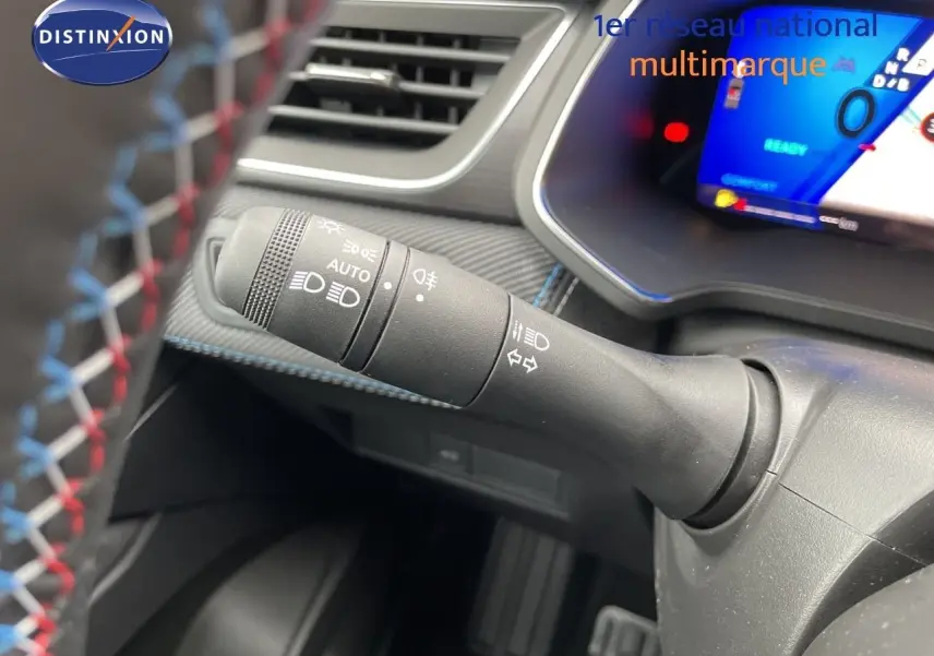 Gros plan sur la commande des feux et clignotants à gauche du volant dans l’habitacle du Renault Symbioz gris Rafale Métal.