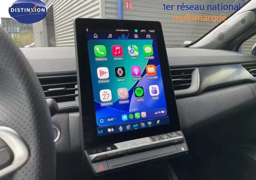Vue intérieure centrée sur l'écran tactile vertical du tableau de bord du Renault Symbioz gris Rafale Métal, avec commandes climatisation visibles.