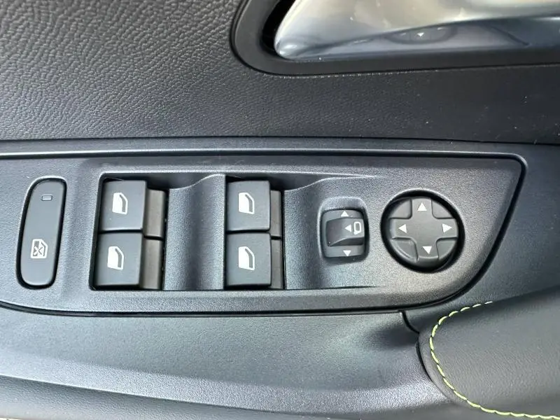 Gros plan sur les commandes de lève-vitres et réglage des rétroviseurs côté conducteur du Peugeot 2008 bleu 2025.