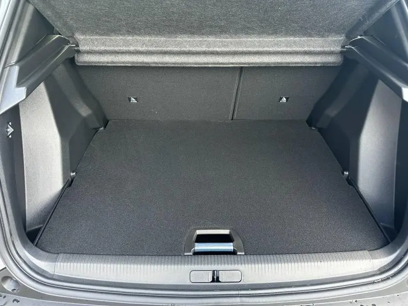 Coffre ouvert vu de l'arrière d'un Peugeot 2008 bleu, montrant un espace de chargement propre et bien fini.