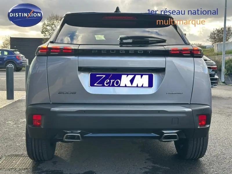 Vue arrière d'un Peugeot 2008 hybride bleu avec feux arrière LED et double sortie d'échappement intégrée.