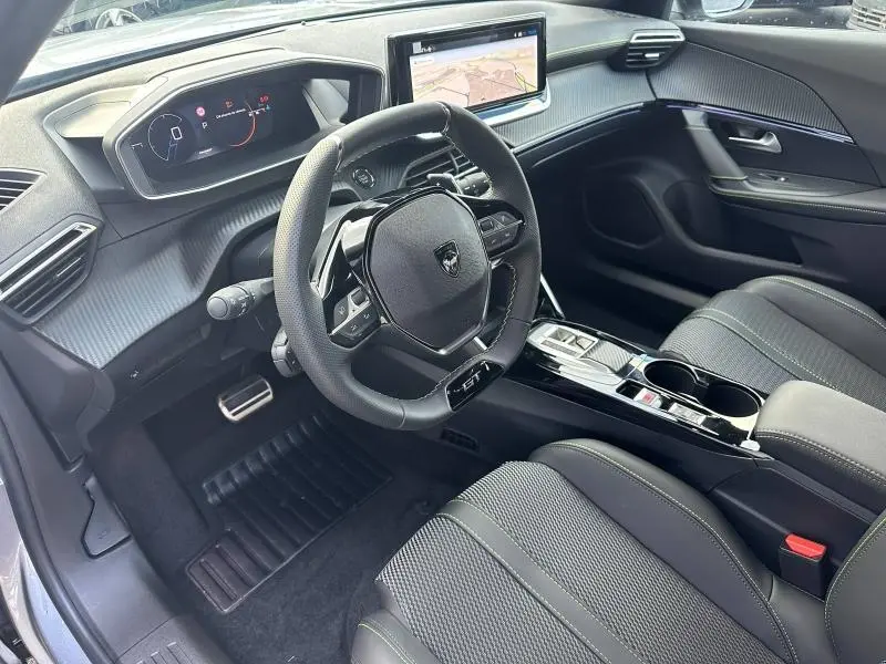 Intérieur du Peugeot 2008 Hybrid 145ch GT 2025, vue côté conducteur, volant cuir GT et écran tactile central.