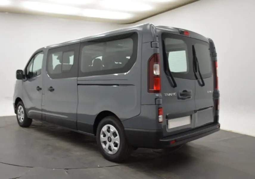 Renault Trafic Fourgon gris clair vu en 3/4 arrière droit, avec vitres latérales et portes arrière battantes.