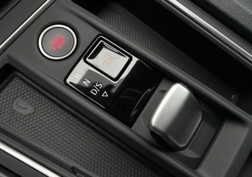 Gros plan sur la commande de boîte automatique et bouton start/stop dans l’habitacle noir du SEAT Leon 2024.