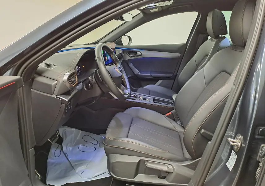 Vue intérieure côté conducteur du CUPRA Formentor gris magnétique 2025, avec sièges cuir noirs et surpiqûres cuivrées.