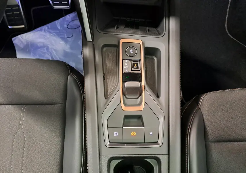 Vue plongeante sur la console centrale du CUPRA Formentor gris magnétique, avec levier de vitesse et boutons cuivrés.