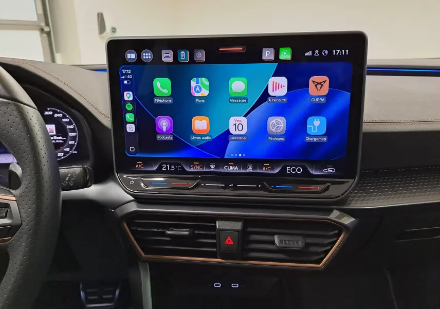 Vue rapprochée de l'écran tactile HD 12,9'' du tableau de bord du CUPRA Formentor gris magnétique, avec commandes climatisation et volant partiel visible.