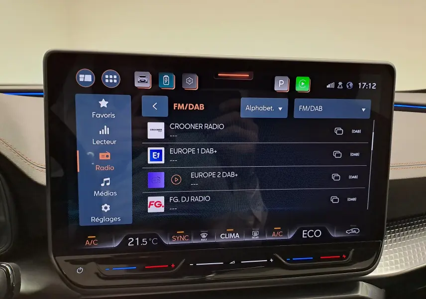 Écran tactile central HD 12,9'' du CUPRA Formentor 2025 affichant les stations radio FM/DAB, avec commandes climatisation en dessous.
