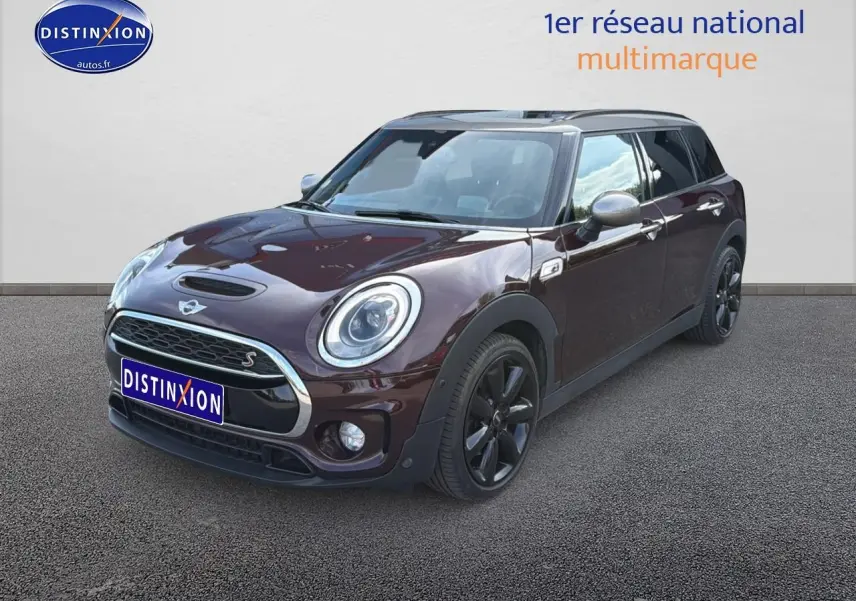 Vue 3/4 avant droite d'une MINI Clubman bordeaux avec calandre chromée et jantes noires.