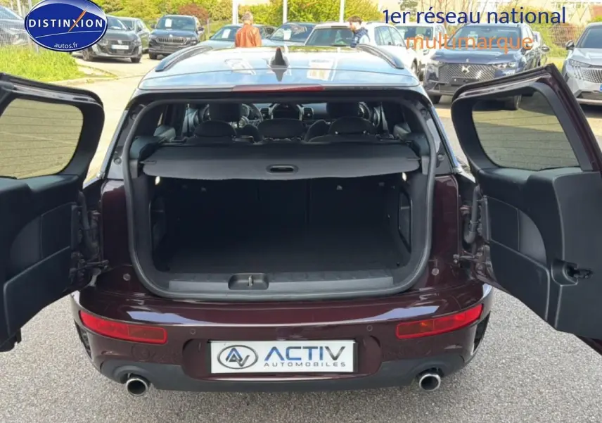 Vue arrière avec portes battantes ouvertes d'une MINI Clubman F54 Cooper SD bordeaux montrant le coffre spacieux.