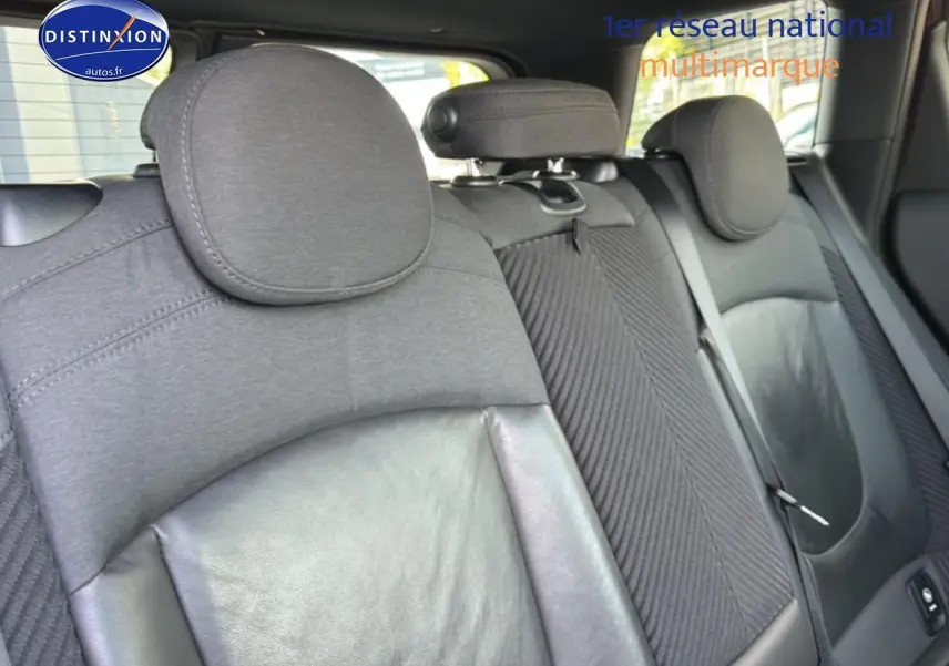 Vue rapprochée des sièges arrière en tissu et cuir noir du MINI Clubman bordeaux, avec appuie-têtes et ceintures visibles.