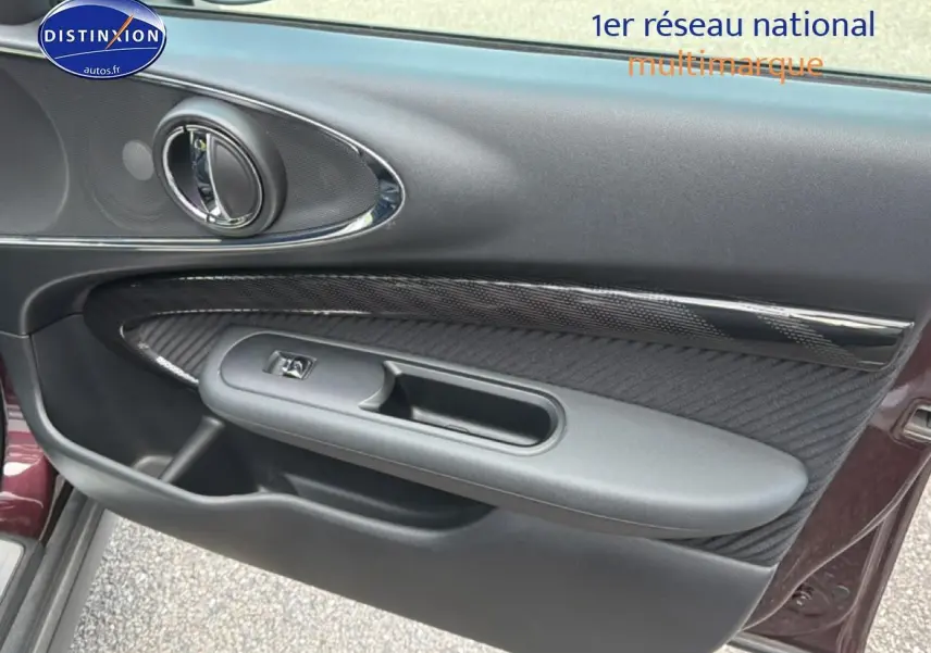 Vue rapprochée de la porte avant gauche bordeaux du MINI Clubman F54 avec insert carbone et poignée chromée.