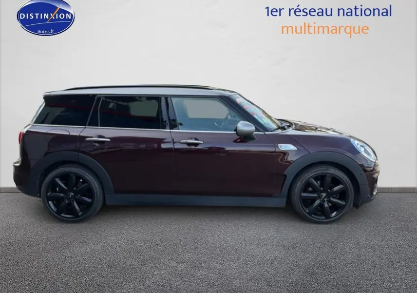 Profil droit d'une MINI Clubman bordeaux avec jantes noires et toit gris sur fond neutre.