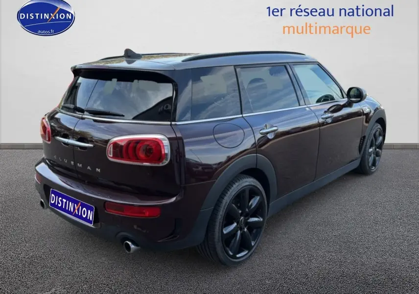 Vue 3/4 arrière droite d'une MINI Clubman Cooper SD bordeaux avec jantes noires et double sortie d'échappement chromée.