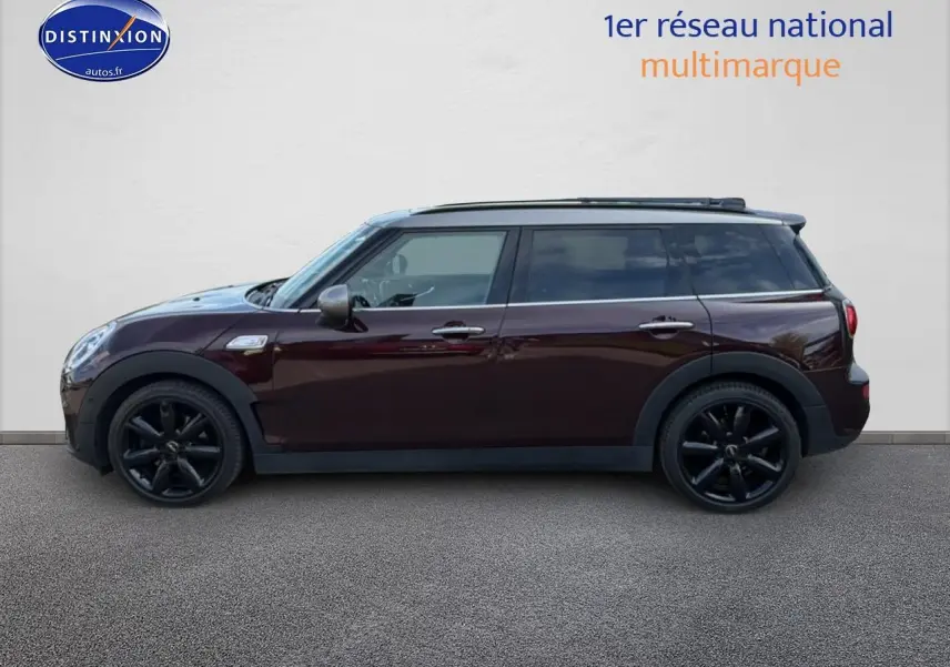 Vue latérale droite d'une MINI Clubman bordeaux avec jantes noires et toit panoramique en verre.