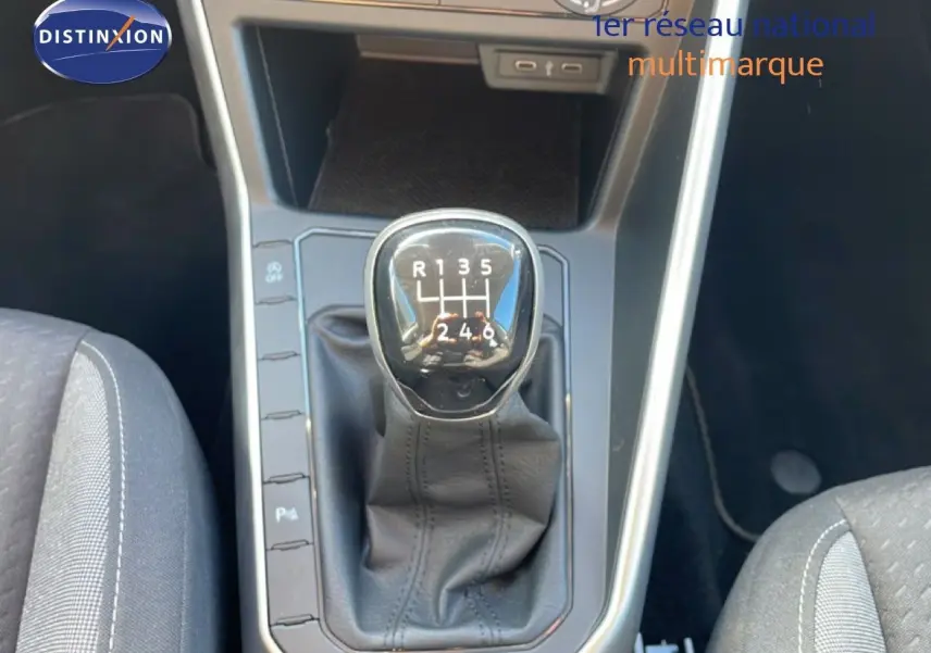 Gros plan sur le levier de vitesse manuel du Volkswagen Taigo 2022 en tissu noir, entouré de la console centrale grise.