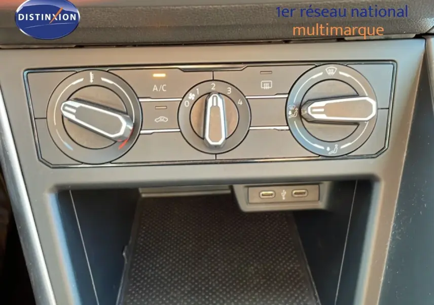 Vue rapprochée du tableau de bord de la Volkswagen Taigo 2022, montrant les commandes de climatisation et deux ports USB.