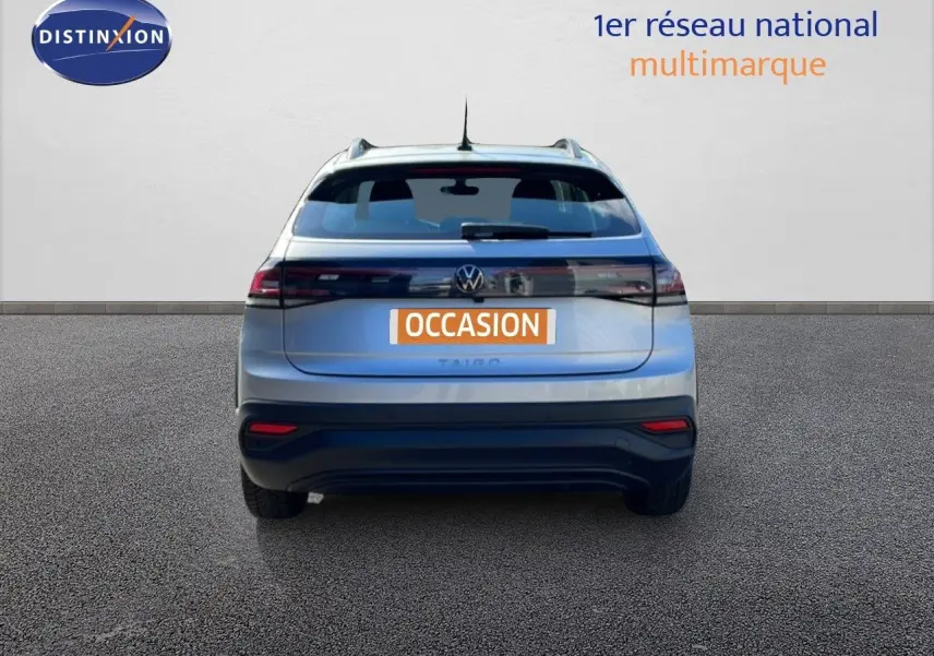 Vue arrière d'un Volkswagen Taigo 1.0 TSI 110CH Life Business en reflet d'argent métal, avec feux LED et plaque "OCCASION".