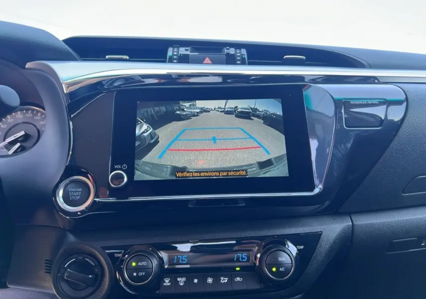 Vue rapprochée de l’écran central du Toyota Hilux 2026 montrant la caméra de recul et les commandes de climatisation.