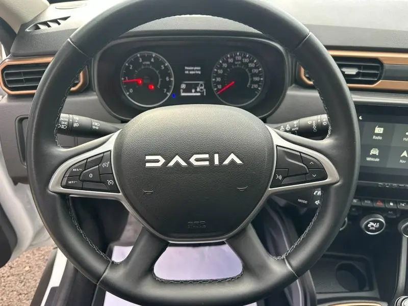 Vue rapprochée du volant multifonction noir du Dacia Duster 2024 avec tableau de bord et écran tactile visibles