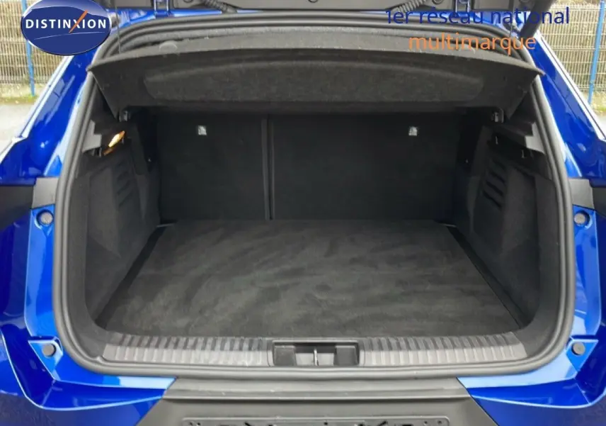 Coffre ouvert vu de l'arrière d'une Renault Symbioz bleu iron metal, montrant un espace de chargement vide et propre.