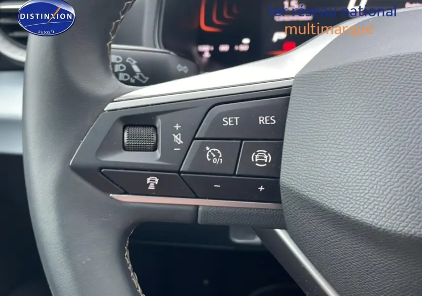 Gros plan sur les commandes de régulateur de vitesse au volant cuir du SEAT Arona blanc Nevada 2025.