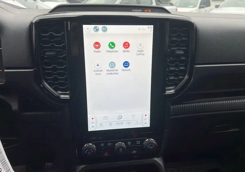 Vue intérieure centrée sur l'écran tactile vertical du Ford Ranger 2025, finition noire avec commandes climatisation visibles.