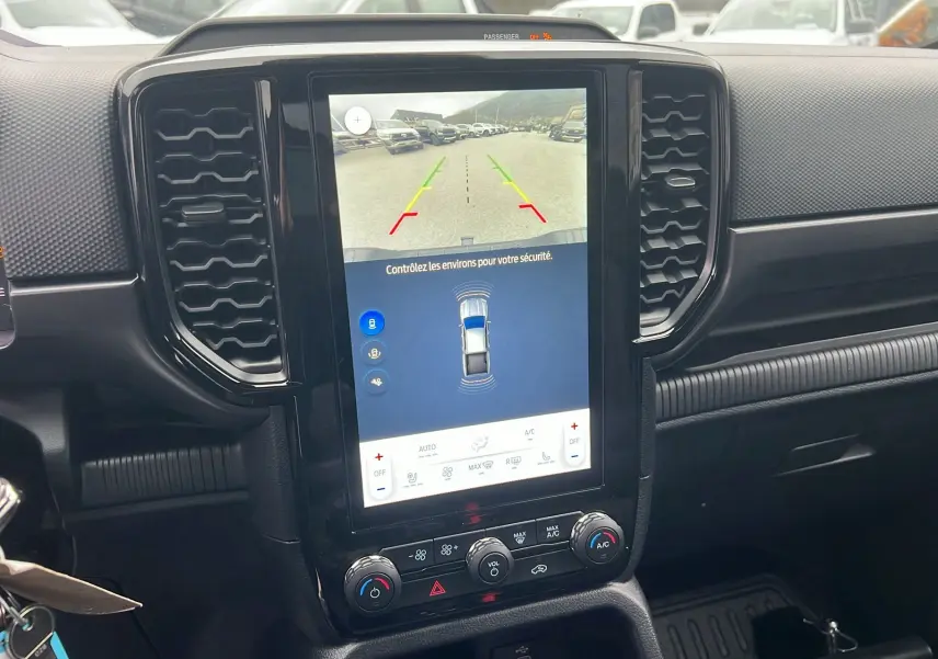 Vue intérieure du tableau de bord du Ford Ranger 2025 gris carbone, avec écran tactile affichant la caméra de recul.