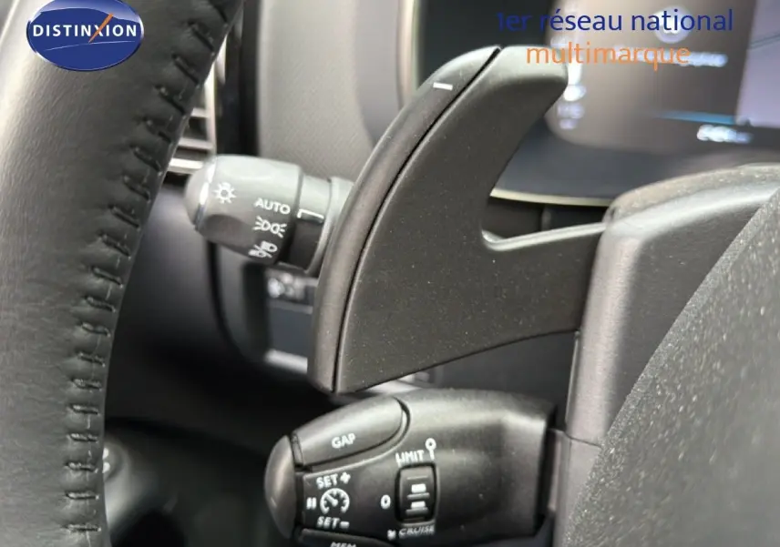 Gros plan sur les commandes au volant du Citroën C5 Aircross 2025, intérieur noir avec palettes de changement de vitesse.