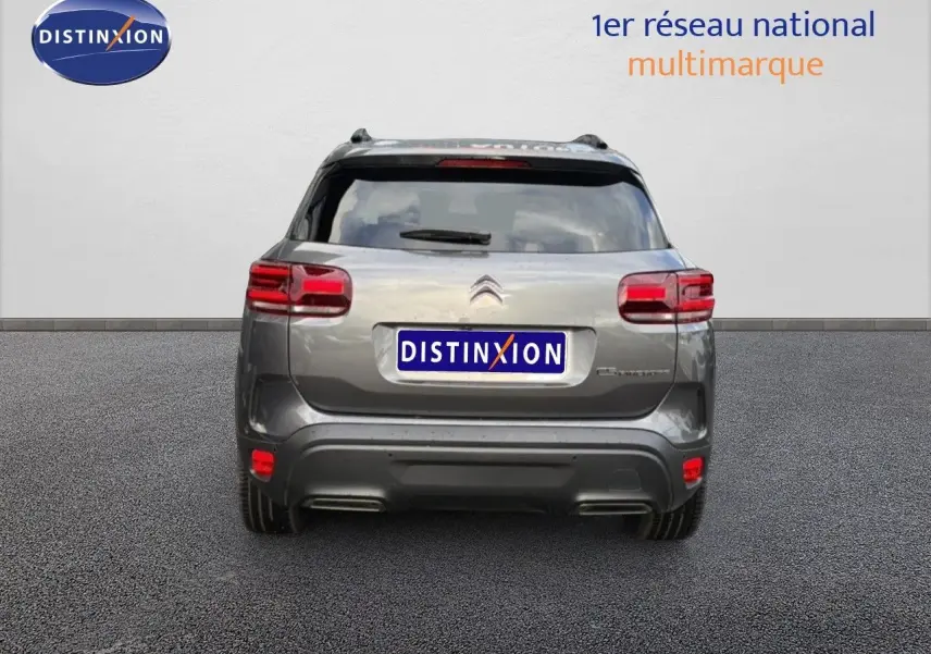 Vue arrière d'un Citroën C5 Aircross gris platinium métal, mettant en valeur ses feux LED et son design compact.