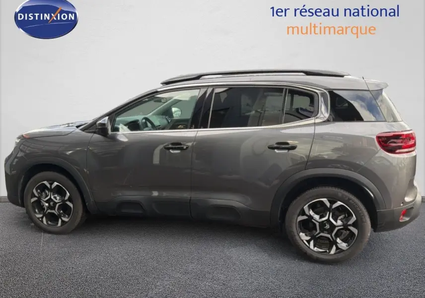 Vue de profil côté gauche d’un Citroën C5 Aircross gris platinium métallisé avec jantes noires et toit ouvrant.