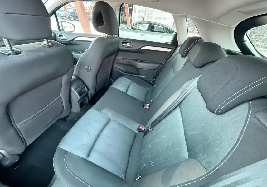 Vue intérieure arrière côté droit montrant les sièges en tissu noir de la Citroën C4 gris 2011.