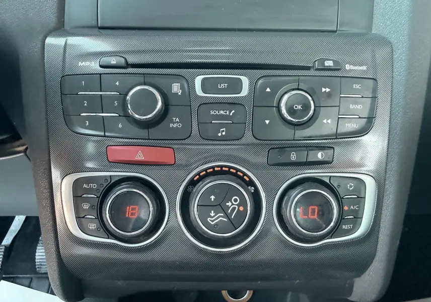 Gros plan sur la console centrale de la Citroën C4 gris, montrant les commandes audio et climatisation digitale.