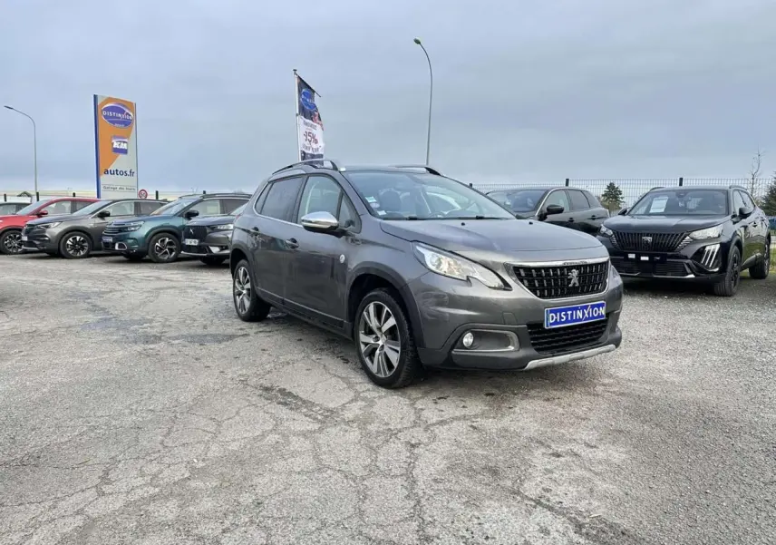 Peugeot 2008 gris foncé en 3/4 avant droit, avec coques de rétroviseurs chrome brillant et jantes aluminium 17''.
