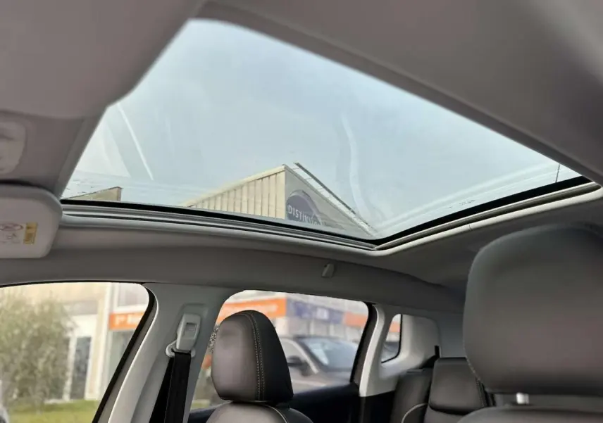 Vue intérieure du toit vitré panoramique du Peugeot 2008 gris foncé, avec sièges avant en cuir noir visibles.