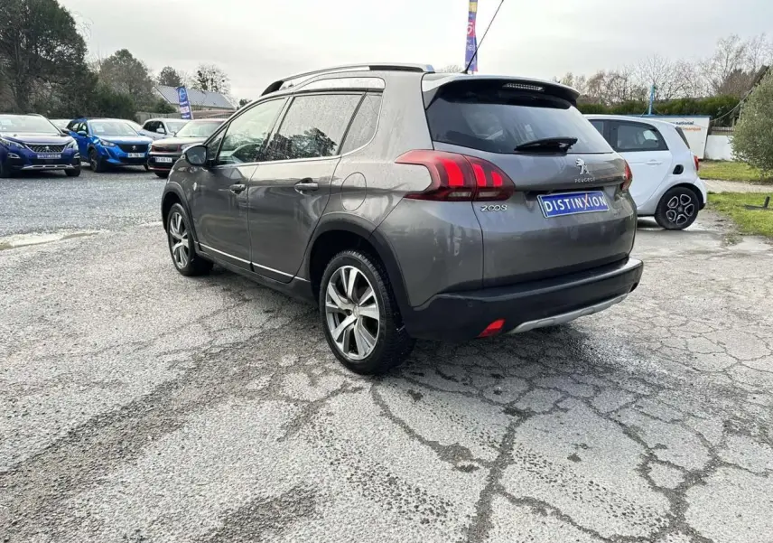 Peugeot 2008 gris foncé vue 3/4 arrière droit, avec jantes aluminium et badges Crossway visibles.